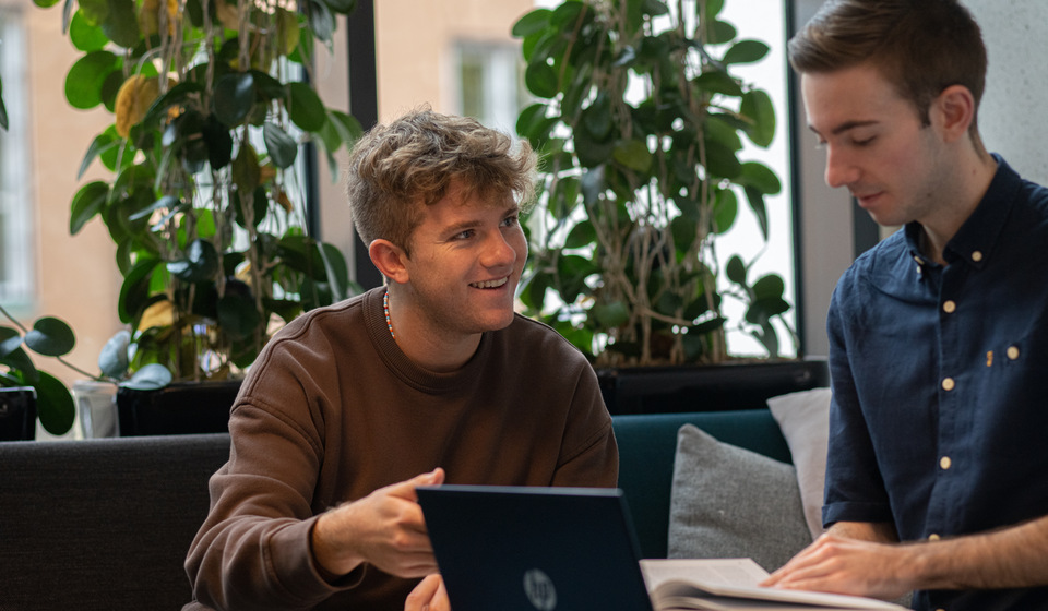 Students talking over laptop.